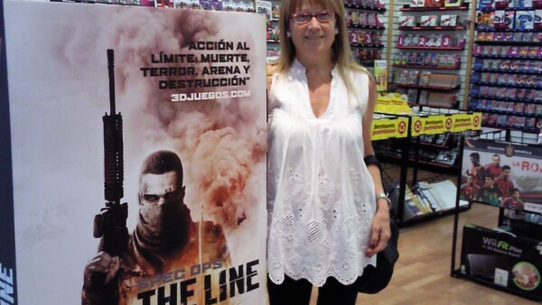 2012 - My mom posing with a SOTL ad at a GAME store during the release week. ❤